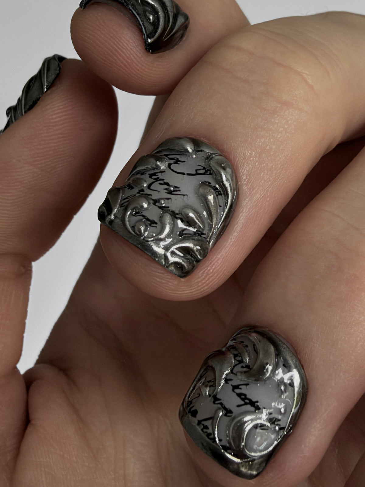FILIGREE très court — Détail des motifs sculptés argentés sur fond noir