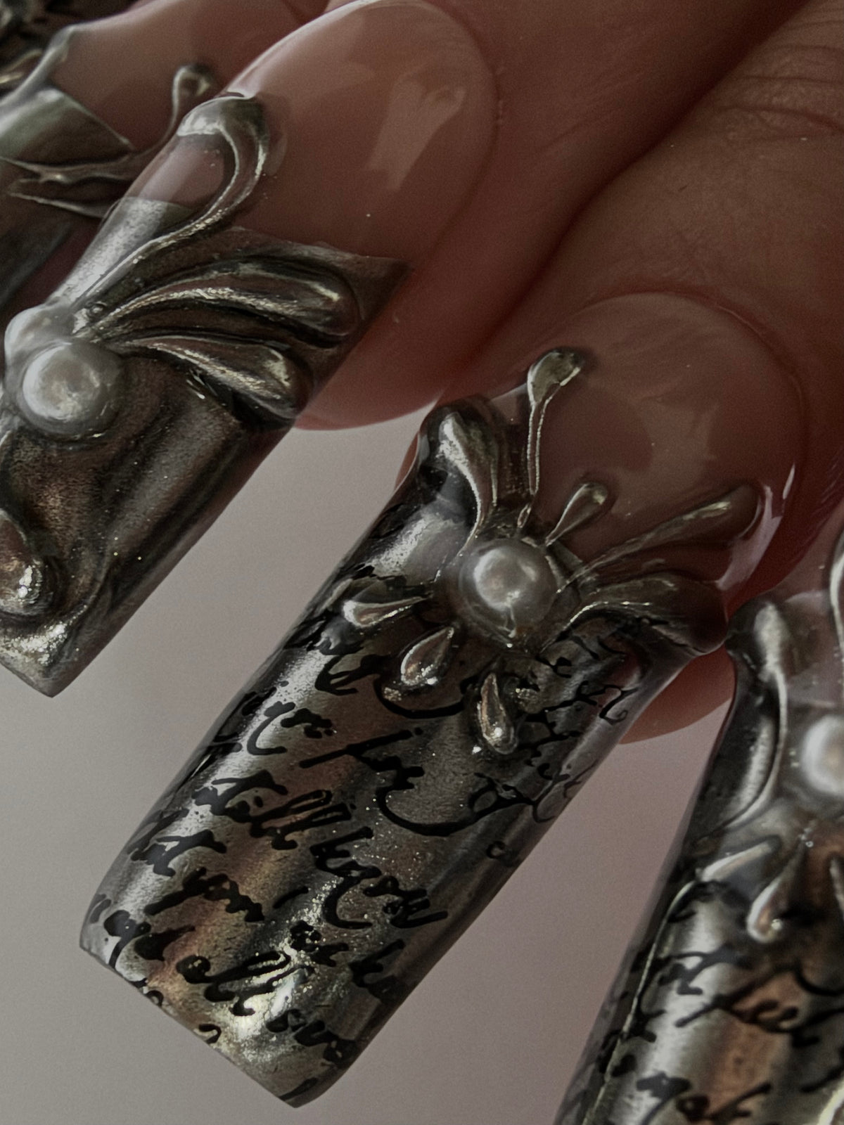 FILIGREE — Détail des arabesques argentées en relief et de la calligraphie noire