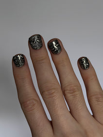 FILIGREE très court — Main portant les ongles très courts noirs et argentés, vue en biais