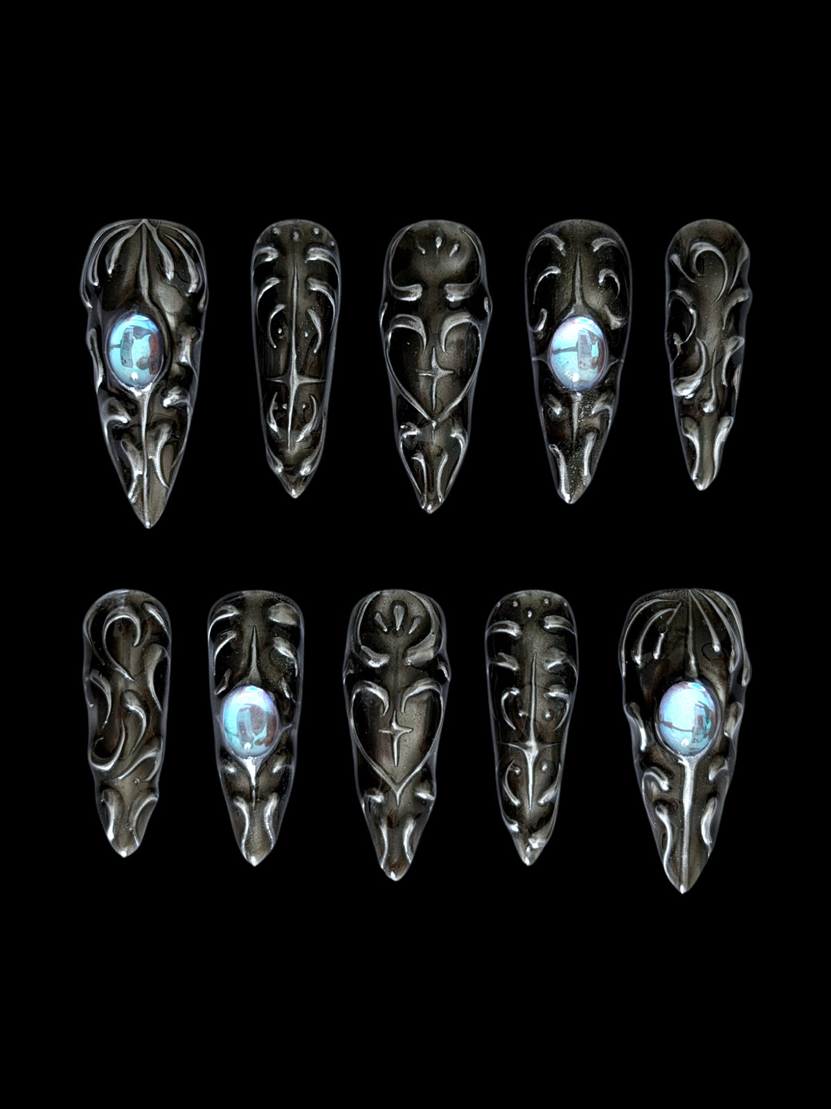 FORGED — Dix press-on Stiletto noirs aux reliefs argentés et cabochons bleus, sur fond noir