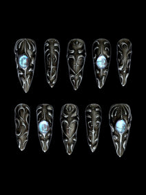 FORGED — Dix press-on Stiletto noirs aux reliefs argentés et cabochons bleus, sur fond noir