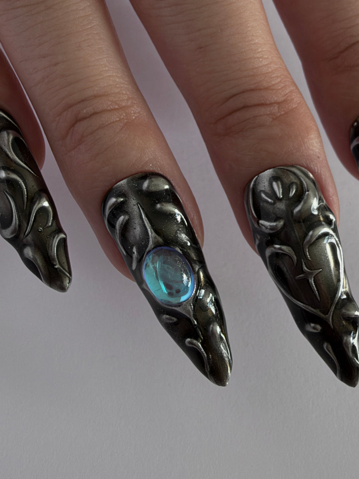 FORGED — Détail des motifs argentés en relief sur fond noir