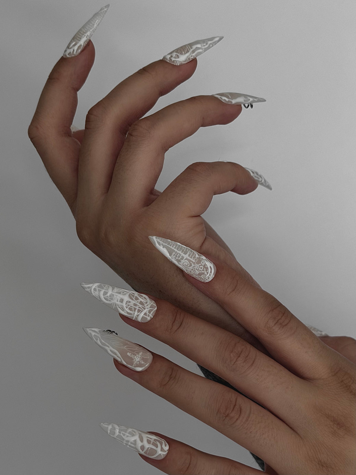PHANTOM — Vue de profil des ongles Stiletto blancs portés sur deux mains