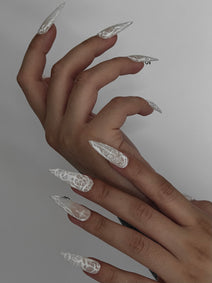 PHANTOM — Vue de profil des ongles Stiletto blancs portés sur deux mains