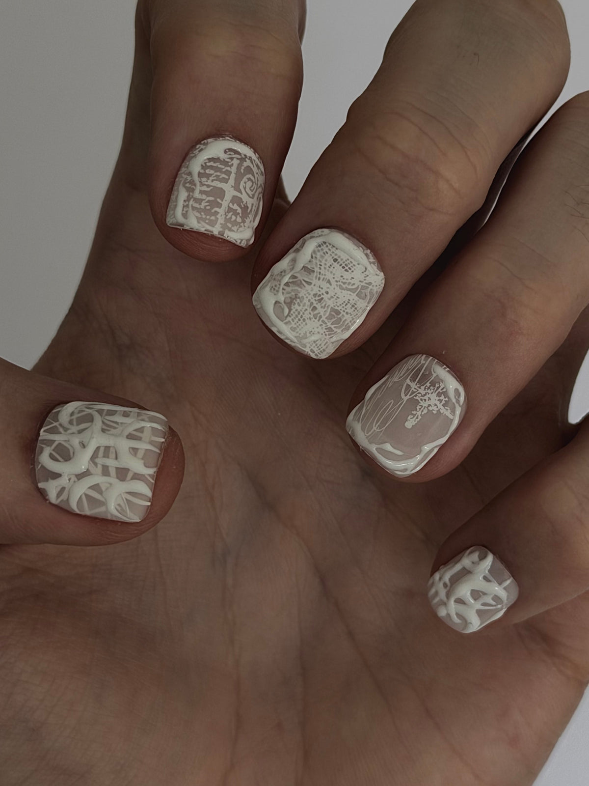 PHANTOM très court — Vue rapprochée des ongles très courts blancs, doigts repliés