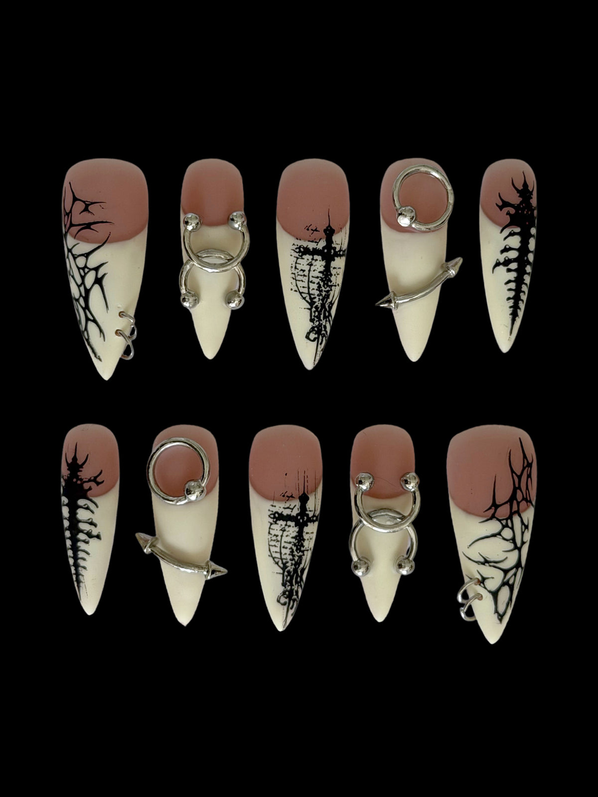 PIERCED — Dix press-on Stiletto nude et ivoire, motifs noirs et piercings argentés, sur fond noir