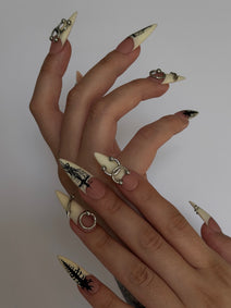 PIERCED — Vue de profil des ongles Stiletto ivoire et nude portés sur deux mains