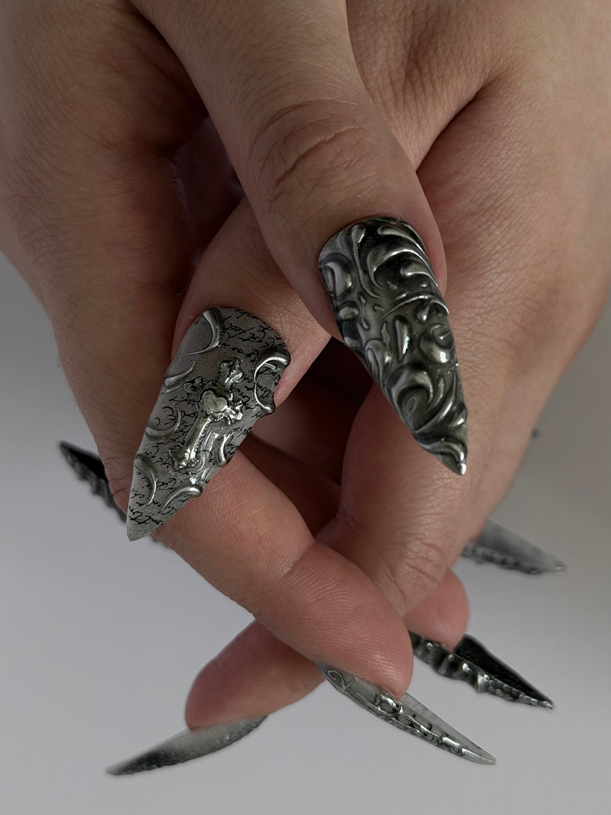 SANCTUM — Gros plan des deux pouces Stiletto et de leurs ornements