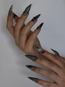 SANCTUM — Vue de profil des ongles Stiletto sculptés portés sur deux mains