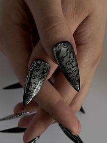 UMBRA — Gros plan des deux pouces Stiletto à la calligraphie noire