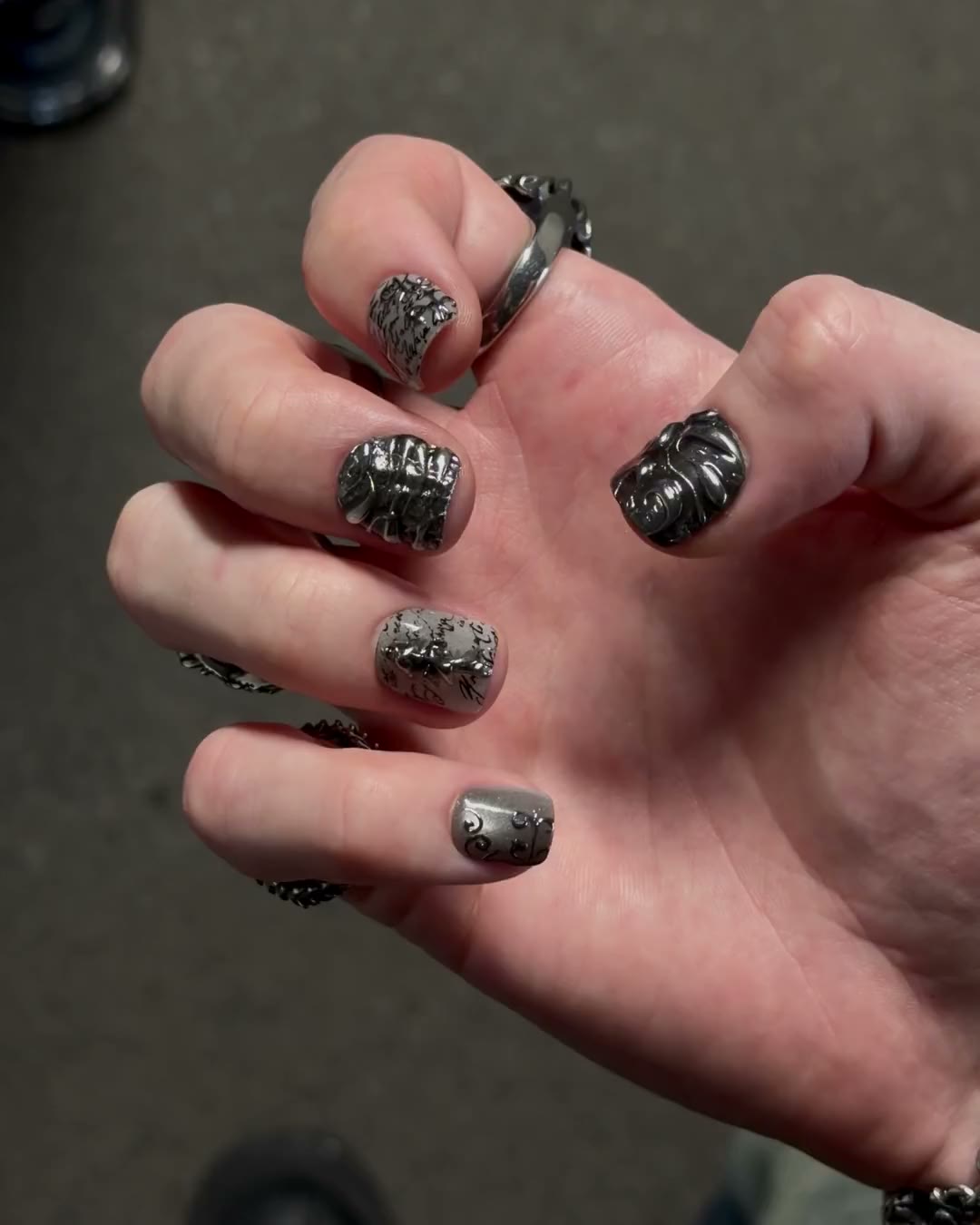 Une main ouverte porte les dix press-on SANCTUM très courts, ajustés ongle par ongle.