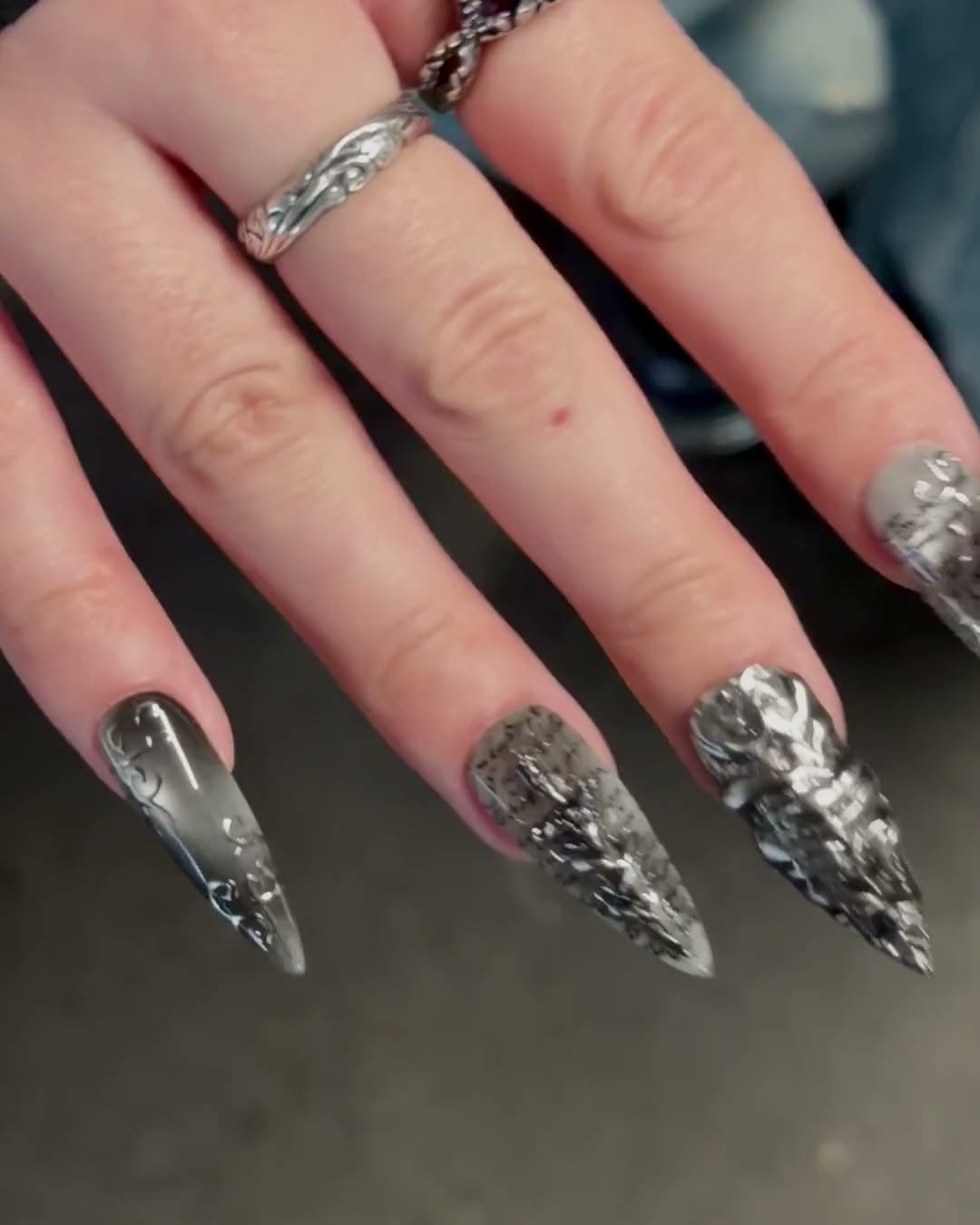 Une main tourne lentement, la lumière glisse sur les stilettos SANCTUM.